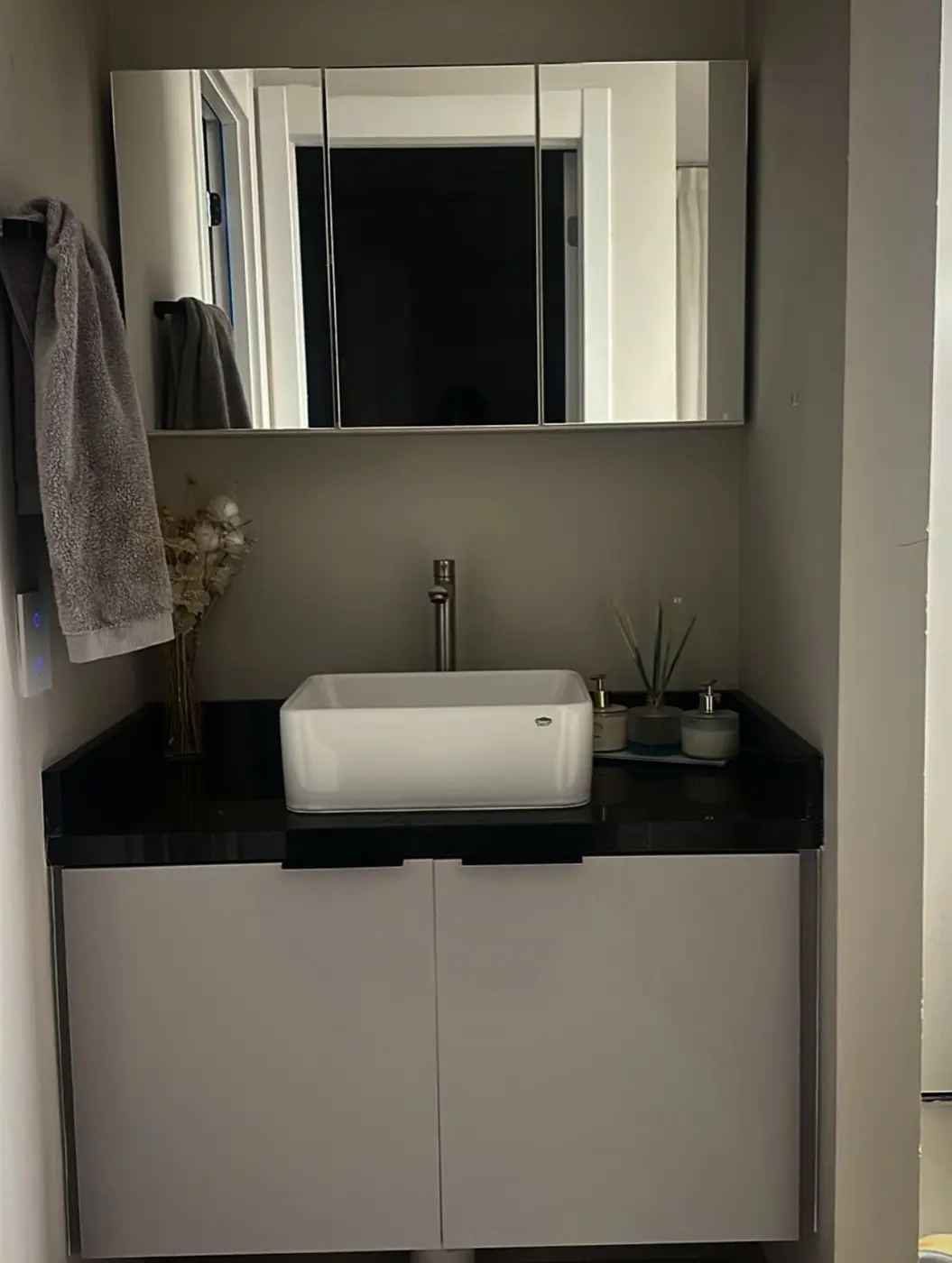 Lavabo com bancada escura e cuba de apoio